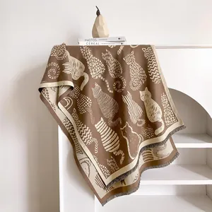 Detail of artistic cat jacquard pattern on thick knit scarf with fine tassel fringe edge