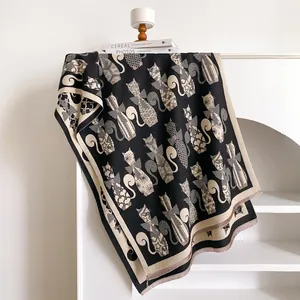 Detailed view of the double-sided jacquard cat pattern and fringed edges on the scarf