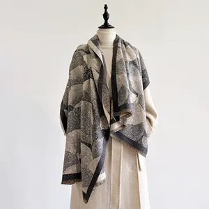 Dettaglio del motivo a ventaglio e frange su sciarpa pashmina nero e grigio