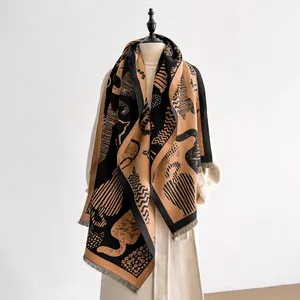 Close-up of abstract cat jacquard pattern and soft fringe on black and beige scarf