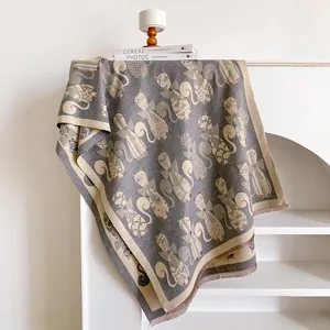 Gray-brown cashmere-like scarf with abstract cat jacquard pattern and fringe trim