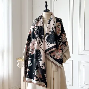 Dettaglio di una sciarpa in cashmere con frange delicate e motivo floreale rosa