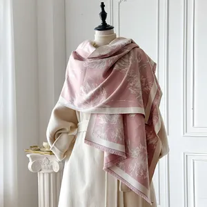 Dettaglio di una sciarpa invernale spessa con piume rosa e morbide frange ai bordi