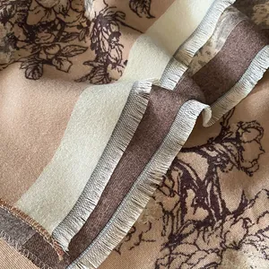 Close-up of retro floral pattern and delicate fringe on earth-toned cashmere scarf