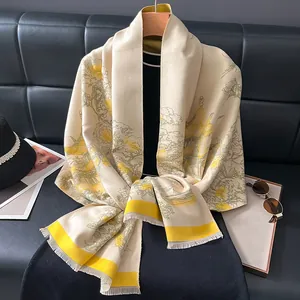 Detail of floral landscape pattern and tassels on beige cashmere-like winter shawl