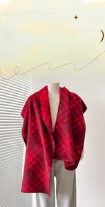 Dettaglio di scialle vintage a scacchi rossi con trama spessa e bordi con punto overlock