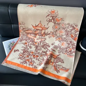 Detailed texture of beige cashmere shawl with traditional floral embroidery and orange tassels