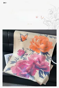 Detail of faux cashmere scarf with peony and butterfly print over smooth black leather