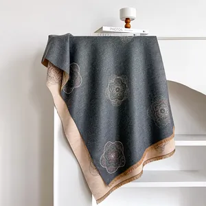 Detail of camellia flower pattern on thick double-sided cashmere-like scarf with tassels