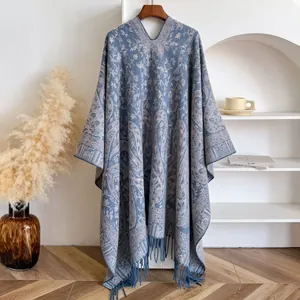 Detail of blue-grey knit shawl with paisley jacquard patterns and delicate fringe trim