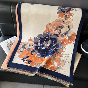 Detail shot of navy floral cashmere-like shawl with intricate orange peony patterns