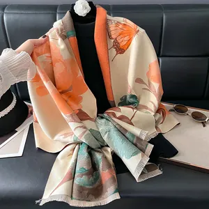 Detailed view of scarf with orange peony flower patterns and soft fringe tassels