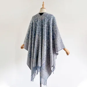 Close-up of blue and grey paisley pattern knit poncho with delicate fringe detail