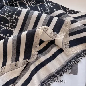 Detailansicht des schwarz-weißen Jacquard-Kaschmirschals mit Streifenmuster und Fransen