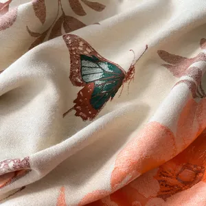 Detailed macro view of woven fabric featuring butterfly and floral patterns on scarf
