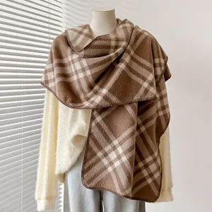 Dettaglio della trama a quadri marrone e beige su una morbida sciarpa effetto cashmere