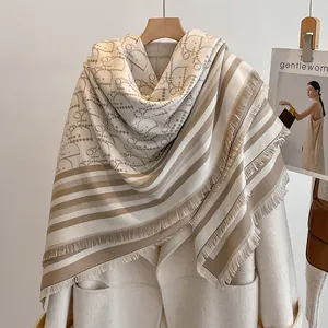 Nahaufnahme von beigem Kaschmir-Schal mit Fransen und luxuriösem Jacquard-Webmuster