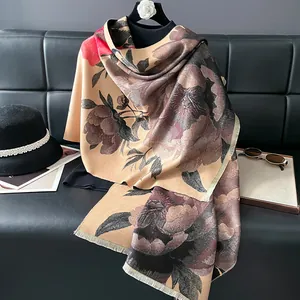 Detail of faux cashmere scarf featuring ink peony floral patterns and delicate fringe trim