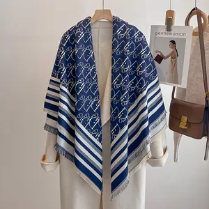 Nahaufnahme eines Jacquard-Kaschmirschals mit Buchstabenmuster und Fransenkante