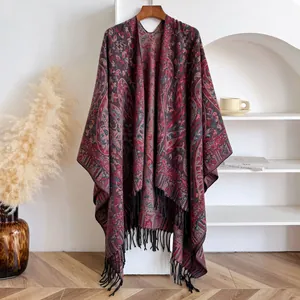 Detail of vintage paisley pattern shawl with elegant black tassel trim on heavy fabric