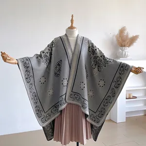 Detailed knit of gray Paisley pattern shawl poncho on an elegant wooden mannequin