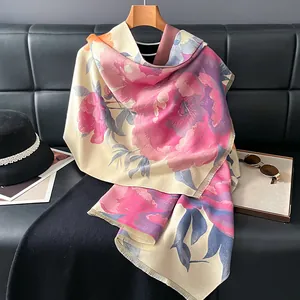 Detail of floral printed cashmere-like scarf with fringe edges in a stylish setup