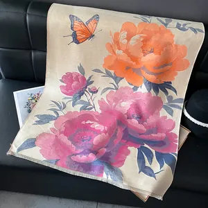 Detail of floral peony and butterfly print on beige pashmina scarf with tassel edges