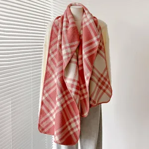 Dettaglio della sciarpa a quadri rosa e beige con tessuto morbido e bordi rifiniti