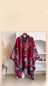 Detail eines roten Strickschals mit Vintage-Blumenmustern auf einem Holzbügel