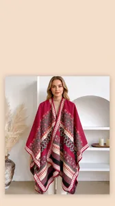 Detail of bohemian knit shawl with geometric patterns and paisley prints hanging on wood