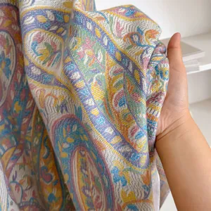 Close-up of soft paisley pashmina fabric showing intricate patterns and premium texture