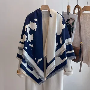 Nahaufnahme eines dicken Schals in Marineblau und Beige mit Fransen auf Mantel
