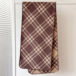 Dettaglio della sciarpa scozzese vintage con bordi rifiniti in marrone e beige