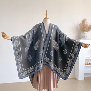 Detail of vintage paisley pattern on a thick bohemian cashmere-style gray shawl cape