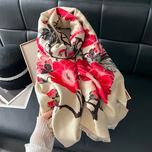 Detail of red floral jacquard on beige cashmere-feel scarf with elegant fringe edges