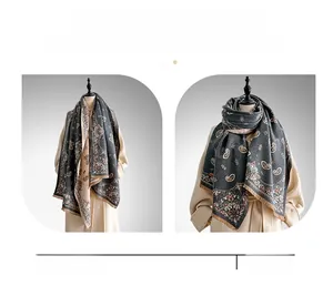 Close-up of grey paisley print scarf showing thick cashmere texture and fine fringe details
