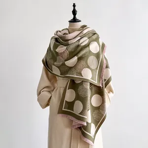 Detailed view of geometric dot pattern on a soft cashmere-like scarf with fringe edges