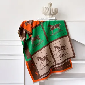 Detail of horse print scarf showing vivid orange and green color-blocking with fringe edge