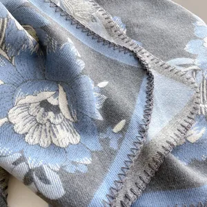 Detailansicht des geblümten Jacquard-Schals mit blau-weißem Muster und Saumstichen