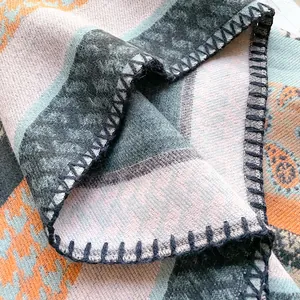 Detailed view of bohemian shawl with paisley patterns and thick blanket-stitch edges