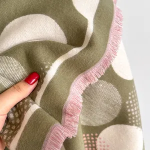 Detail of soft knit shawl texture with geometric polka dots and colorful fringe tassels