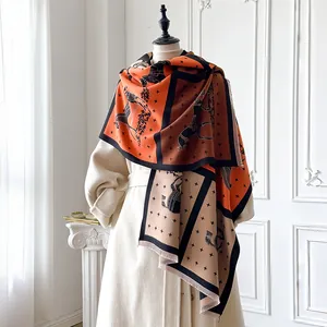 Detail of horse and carriage pattern on thick orange and beige plaid cashmere scarf