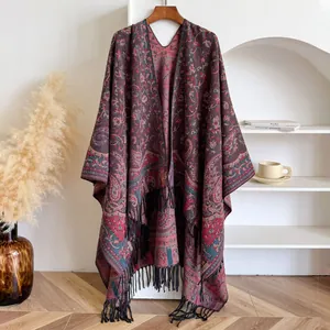 Detalle del patrón jacquard de cachemira y flecos negros en el chal de punto rojo oscuro