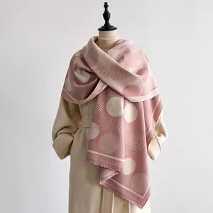 Detail of pink and beige geometric dot pattern on soft pashmina shawl with tassel edge