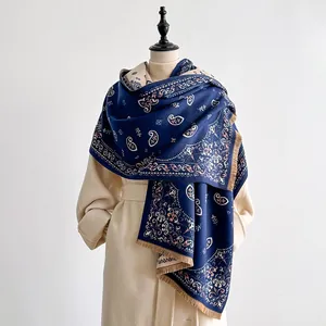 Close-up of navy paisley pattern scarf with soft fringe and thick knitted texture