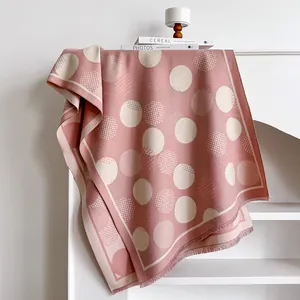Detail of pink cashmere-feel shawl showing geometric polka dot patterns and fringe edges