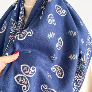 Detailed macro view of navy blue paisley print and soft brushed texture of the warm scarf