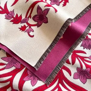 Detail shot of vintage floral cashmere scarf featuring red flowers and dense fringe trim