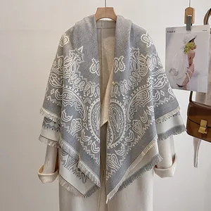 Detailansicht eines grau-beigen Paisley-Jacquard-Schals mit langen Fransenrändern