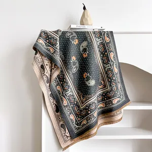 Nahaufnahme eines Paisley-Jacquard-Schals mit Quasten-Details in warmer Heim-Atmosphäre